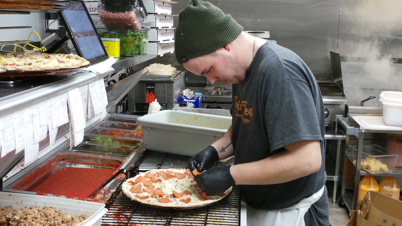 Making pizza at the prep station